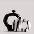 Set of two ceramic vases – tall matte black circular vase and compact white zebra stripe square vase