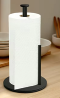 Matte black stainless steel freestanding paper towel holder with heavy weighted base on a kitchen countertop