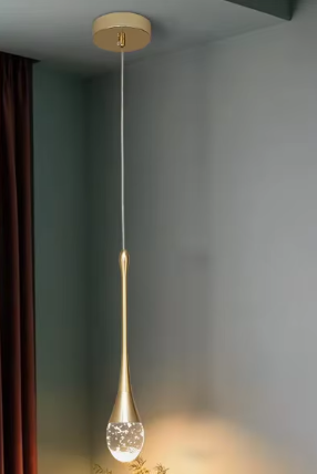 Crystal LED pendant light with gold finish hanging from ceiling in a luxury interior