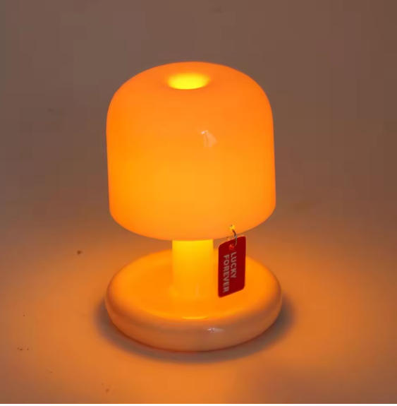 Mushroom shaped LED night light glowing warm amber on a white round base
