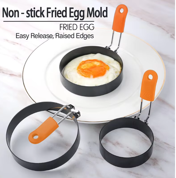 Non-stick fried egg mold rings with orange silicone handles showing a perfectly shaped fried egg on a white plate