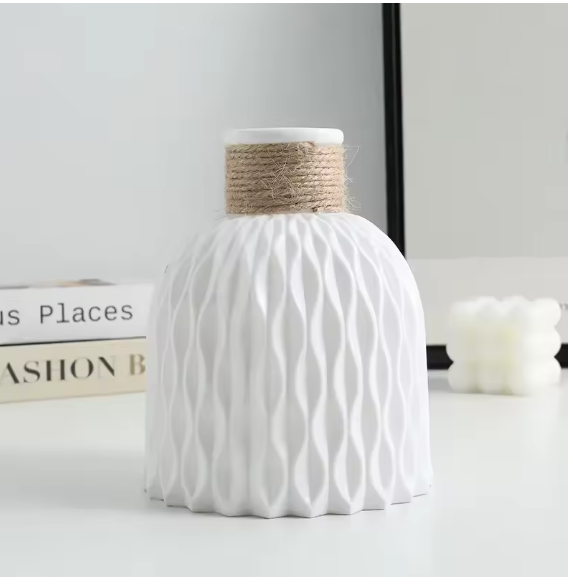 White Nordic water ripple texture vase with natural jute rope collar, styled on a desk with books